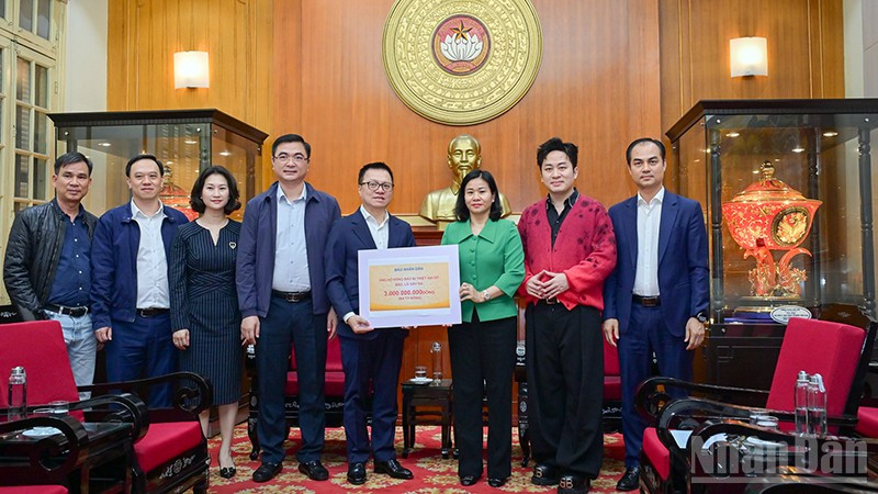 Tổng Biên tập Báo Nhân Dân Lê Quốc Minh trao kinh phí ủng hộ đồng bào khắc phục hậu quả bão, lũ. (Ảnh: BẢO LONG)