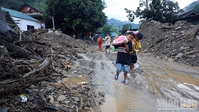 Thiếu nhi vùng lũ Nghệ An nhận lương thực cứu trợ từ các đoàn từ thiện. (Ảnh: TRUNG HIẾU)