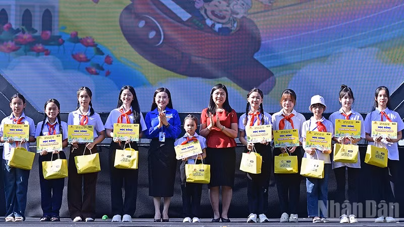 Bí thư Trung ương Đoàn, Chủ tịch Hội đồng Đội Trung ương Nguyễn Phạm Duy Trang (thứ 5 từ trái sang) cùng đại diện Ban tổ chức Ngày hội trao học bổng tặng thiếu nhi vượt khó học tốt.