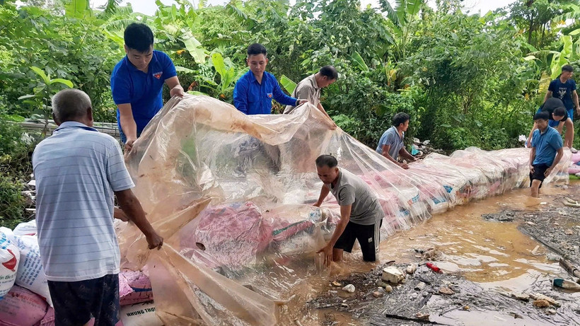 Đoàn viên, thanh niên tình nguyện hỗ trợ bà con đắp bờ chắn dòng chảy tại xã Nam Phù (Hà Nội).