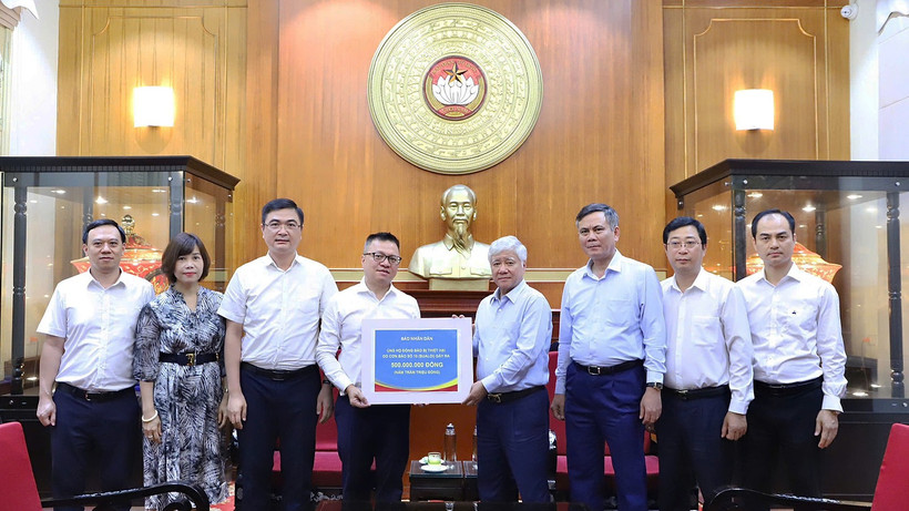 Đồng chí Đỗ Văn Chiến (thứ 4 từ phải sang) tiếp nhận số tiền ủng hộ từ tập thể lãnh đạo, cán bộ, người lao động Báo Nhân Dân.