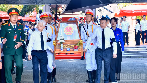 Nguyên Chủ tịch nước Nguyễn Minh Triết và Thủ tướng Chính phủ Lê Minh Hưng cùng thực hiện nghi thức đưa hài cốt các Anh hùng liệt sĩ từ Công viên Lê Thị Riêng về Nghĩa trang Liệt sĩ Thành phố Hồ Chí Minh. (Ảnh: THANH GIANG)