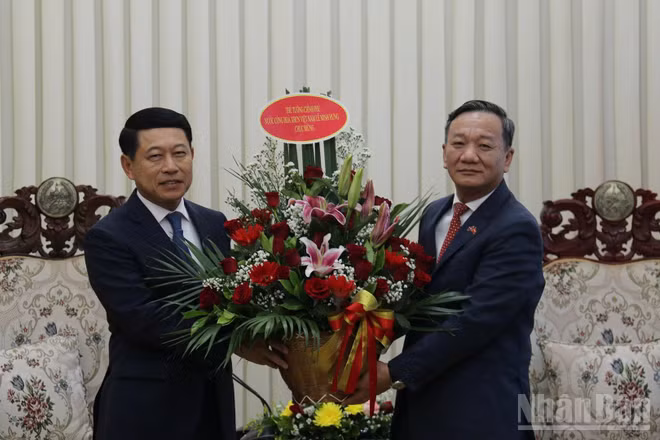 Đại sứ Nguyễn Minh Tâm chuyển lẵng hoa của Thủ tướng Lê Minh Hưng chúc mừng Thủ tướng Lào Saleumxay Kommasith. (Ảnh: DUY TOÀN)