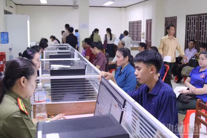 Cán bộ Cục Quản lý hộ tịch và xây dựng cơ sở, Bộ Công an Lào, hướng dẫn người dân Lào làm thủ tục căn cước công dân. (Ảnh: DUY TOÀN)