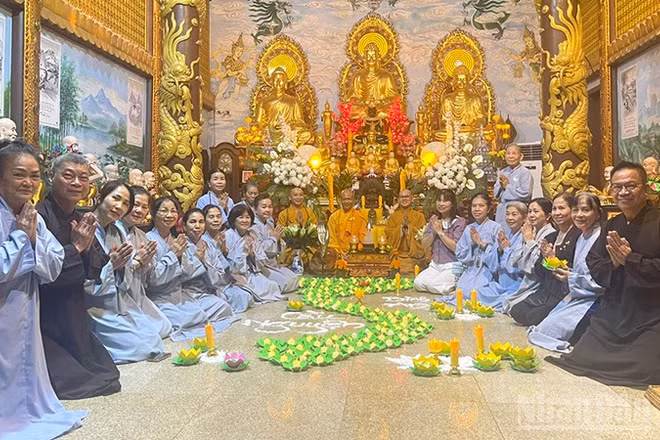 Cộng đồng người Việt Nam tại Lào thắp nến hoa đăng cầu nguyện cho đồng bào. (Ảnh: DUY TOÀN)