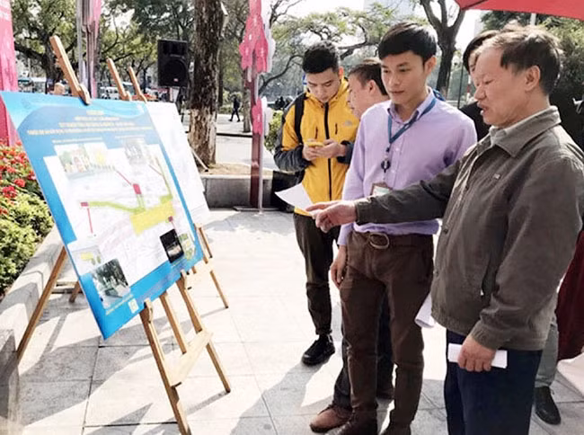 Chuyên viên Ban Quản lý đường sắt đô thị Hà Nội trao đổi thông tin về phương án xây dựng ga ngầm C9 với người dân. Ảnh: MINH TƯỜNG