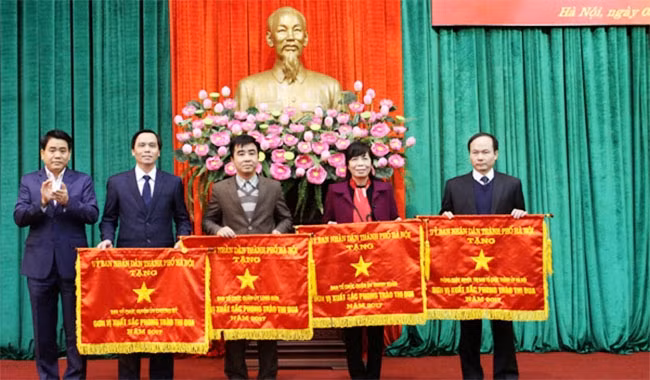 Phó Bí thư Thành ủy, Chủ tịch UBND thành phố Nguyễn Đức Chung trao Cờ thi đua cho đại diện các đơn vị có thành tích xuất sắc trong phong trào thi đua năm 2017. Ảnh: TRUNG ANH