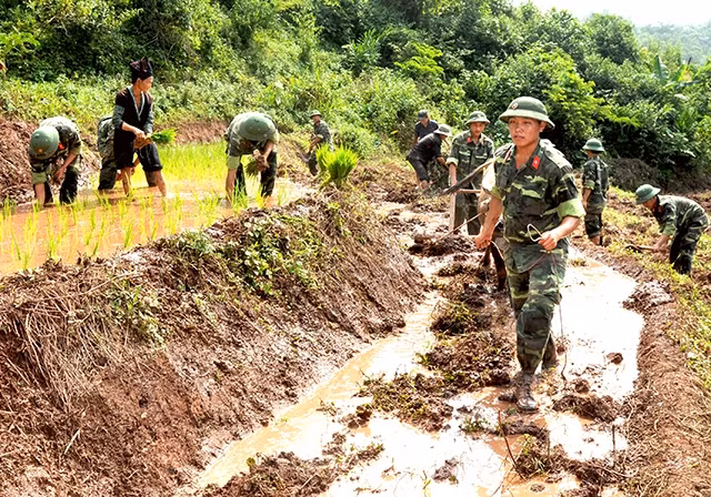 Cán bộ, chiến sĩ Tiểu đoàn 4, Lữ đoàn 82 (Quân khu 2) giúp đồng bào dân tộc thiểu số huyện Mường Nhé (tỉnh Điện Biên) sản xuất nông nghiệp. Ảnh: MINH HUỆ