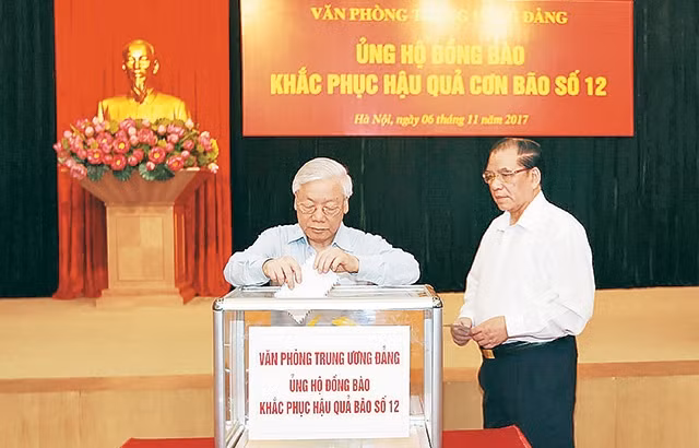 Tổng Bí thư Nguyễn Phú Trọng và nguyên Tổng Bí thư Nông Ðức Mạnh tham gia quyên góp ủng hộ đồng bào khắc phục hậu quả thiên tai. Ảnh: TRÍ DŨNG (TTXVN)