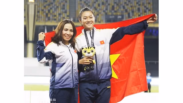 Vận động viên điền kinh Lê Tú Chinh (bên phải) nhận Huy chương vàng tại SEA Games 29. Ảnh: LÂM THỎA