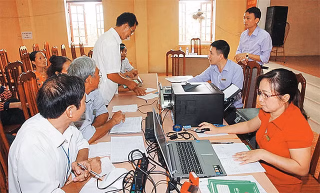Cán bộ Ngân hàng Chính sách xã hội Hà Nội hướng dẫn hộ nghèo huyện Phúc Thọ làm thủ tục vay vốn đầu tư sản xuất và xây dựng, sửa chữa nhà ở. Ảnh: THÁI HIỀN