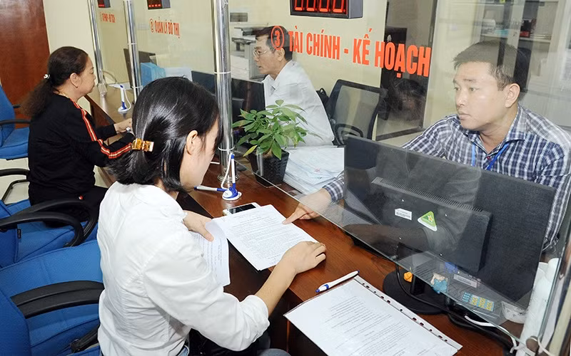 Cán bộ Trung tâm hành chính công TP Vĩnh Phúc (tỉnh Vĩnh Phúc) giải quyết các thủ tục hành chính cho người dân. Ảnh: THANH HÀ