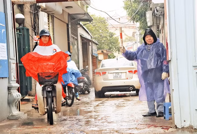 Ông Phạm Đình Chính phân luồng giao thông tại cổng làng Lai Xá.