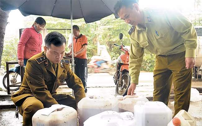 Cán bộ Đội Quản lý thị trường số 6 kiểm tra, thu giữ rượu không rõ nguồn gốc tại một cửa hàng trên đường Đại Mỗ, phường Đại Mỗ (quận Nam Từ Liêm). Ảnh: CÔNG HÙNG