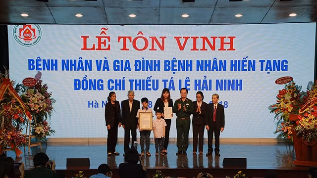 Lãnh đạo Bệnh viện T.Ư Quân đội 108 (Bộ Quốc phòng) trao thẻ Bảo hiểm y tế khám, chữa bệnh ban đầu tặng thân nhân Thiếu tá Lê Hải Ninh. Ảnh: Ðức Thuấn
