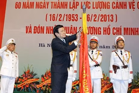 Chủ tịch nước Trương Tấn Sang gắn Huân chương Hồ Chí Minh lên Cờ truyền thống của Lực lượng Cảnh vệ Công an nhân dân. 