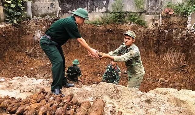 Lực lượng chức năng đưa đạn pháo lên khỏi mặt đất.