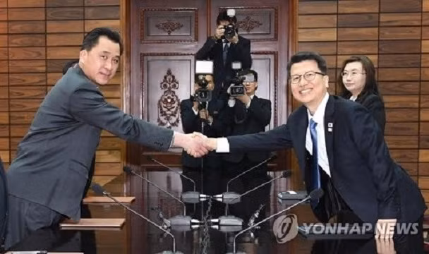 Ông Lee Joo-tae, trưởng đoàn đàm phán của Triều Tiên (bên phải) bắt tay người đồng nhiệm Triều Tiên Hwang Chung-song, tại cuộc đàm phán cấp chuyên viên về việc Triều Tiên tham gia Paralympics. (Ảnh: Y