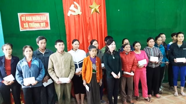 Bà Thanh Hằng, Phó Chủ tịch Hội người Việt Nam tại Pháp trao quà cho các hộ nghèo bị ngập lũ.