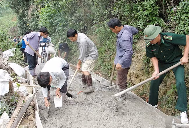 Cán bộ, chiến sĩ Đồn Biên phòng Chi Ma giúp người dân xã Yên Khoái làm đường giao thông nông thôn.