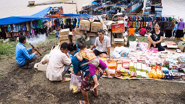 Người bán, kẻ mua bên dòng sông.