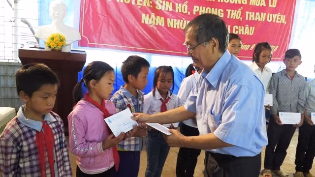 Đại diện Hội người Việt Nam tại Pháp trao học bổng cho học sinh nghèo vùng lũ huyện Phong Thổ.