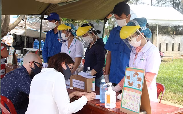 Tình nguyện viên hỗ trợ du khách nước ngoài tại chốt kiểm soát trên đường Trường Sa (quận Ngũ Hành Sơn, TP Đà Nẵng).