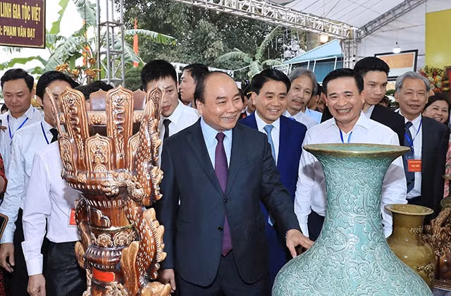 Thủ tướng Nguyễn Xuân Phúc thăm một gian hàng tại triển lãm trưng bày, giới thiệu sản phẩm gốm sứ Bát Tràng. Ảnh: THỐNG NHẤT (TTXVN)