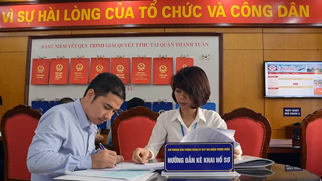 Việc cải cách chế độ tiền lương khu vực hành chính là một trong những bước đi đột phá trong công tác cán bộ. Trong ảnh: Cán bộ chi nhánh văn phòng đăng ký đất đai quận Thanh Xuân (Hà Nội) hướng dẫn ng