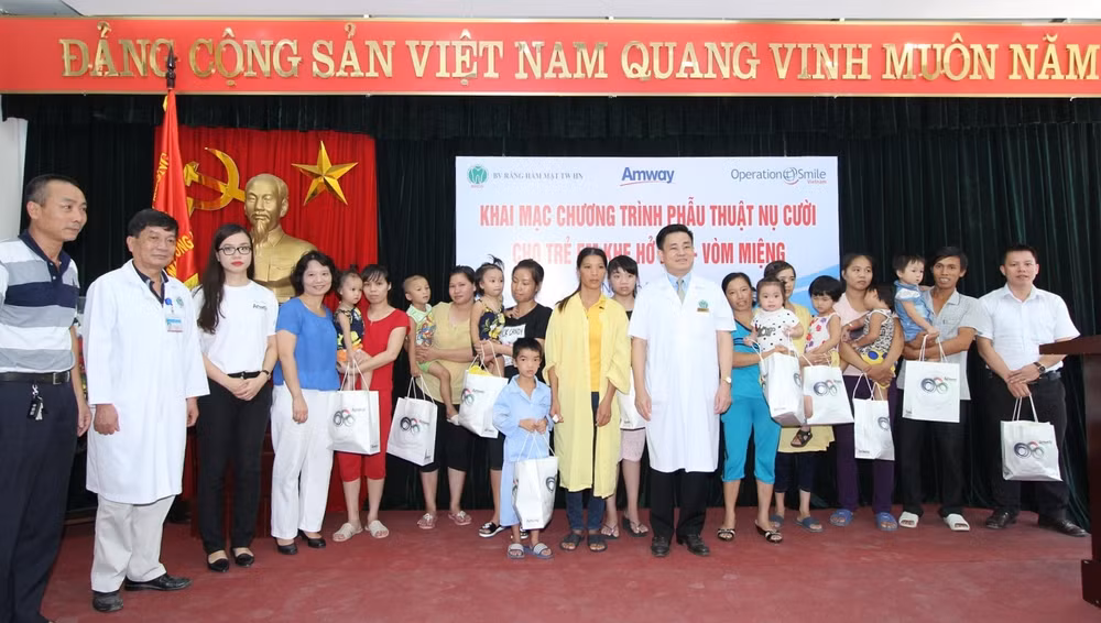 Đại diện Ban tổ chức và Amway trao quà cho gia đình các cháu tham gia phẫu thuật
