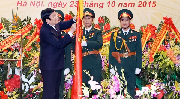 Chủ tịch nước Trương Tấn Sang gắn Huân chương Quân công hạng nhất lên Quân kỳ Quyết thắng của Tổng cục Tình báo Quốc phòng Việt Nam. Ảnh: NGUYỄN KHANG (TTXVN)