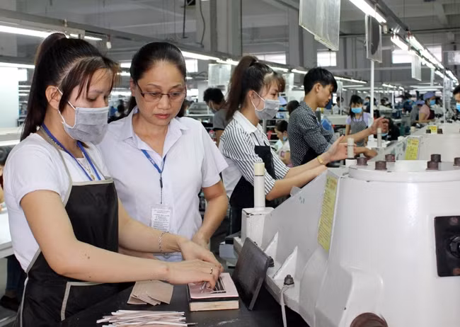Đảng viên Nguyễn Thị Hương (thứ hai từ trái sang) hướng dẫn công nhân trong dây chuyền sản xuất.