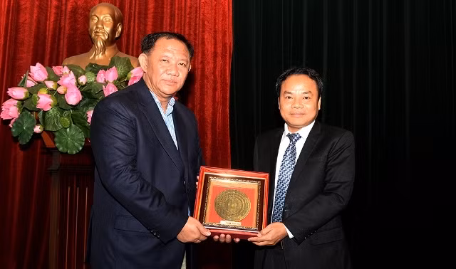 Phó Tổng Biên tập Báo Nhân Dân Đinh Như Hoan trao quà lưu niệm cho đồng chí Vilaythong Sisanonh, Viện trưởng Viện Văn hóa, Thông tin và Du lịch Lào. (Ảnh: THỦY NGUYÊN)