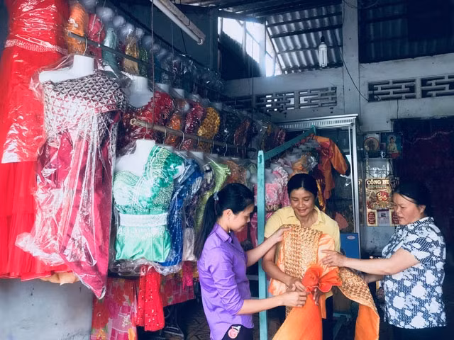 Chị Kim Thị Nga (đứng giữa) vay 30 triệu đồng từ NHCSXH để mở cửa hàng may và cho thuê áo cưới.