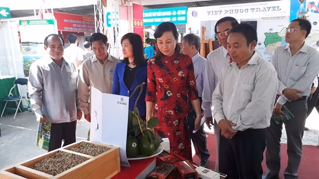 Các đại biểu và người dân tham quan một gian hàng tại Hội chợ, triển lãm.
