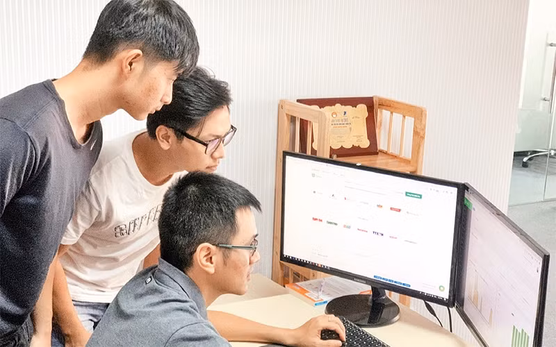 Trần Viết Quân (người ngồi) cùng các cộng sự thao tác trên ứng dụng Tanca.