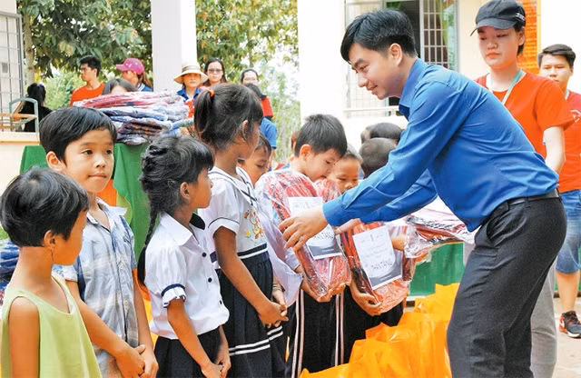 Đoàn viên, thanh niên trao quà tặng học sinh nghèo.