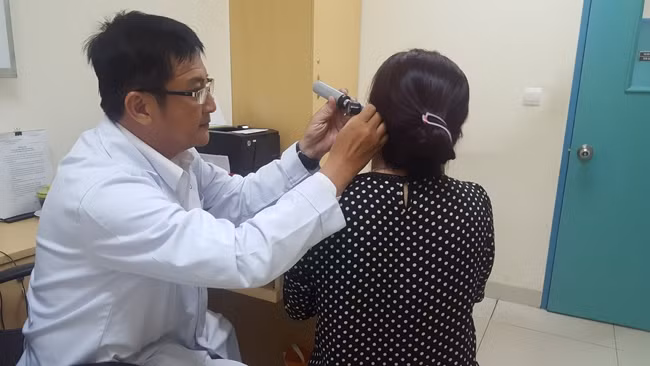 GS Hữu đang khám cho người bệnh bị viêm tai ngoài.