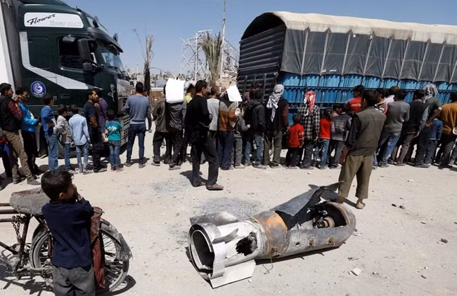 Người dân thị trấn Douma của Syria xếp hàng nhận viện trợ lương thực. (Ảnh: Reuters)