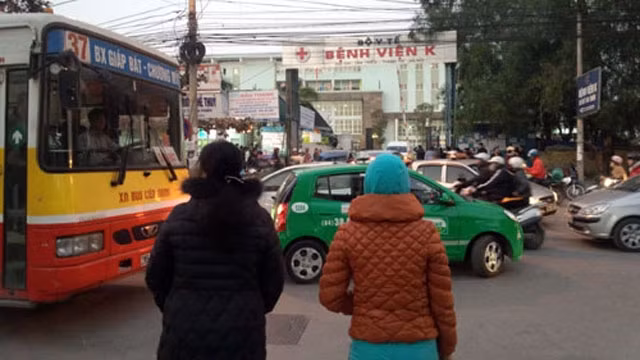 Muốn qua đường, các bệnh nhân ở Viện K phải dìu nhau thành từng tốp để tránh xe cộ. (Ảnh: Vietnamnet)