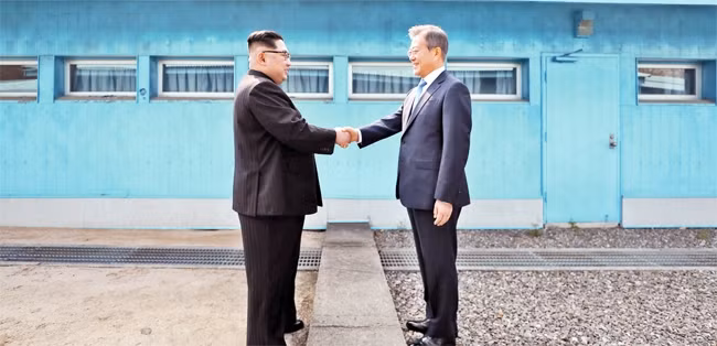 Nhà lãnh đạo Triều Tiên Kim Jong-un và Tổng thống Hàn Quốc Moon Jae-in bắt tay tại đường ranh giới quân sự, Bàn Môn Điếm ngày 27-4-2018.