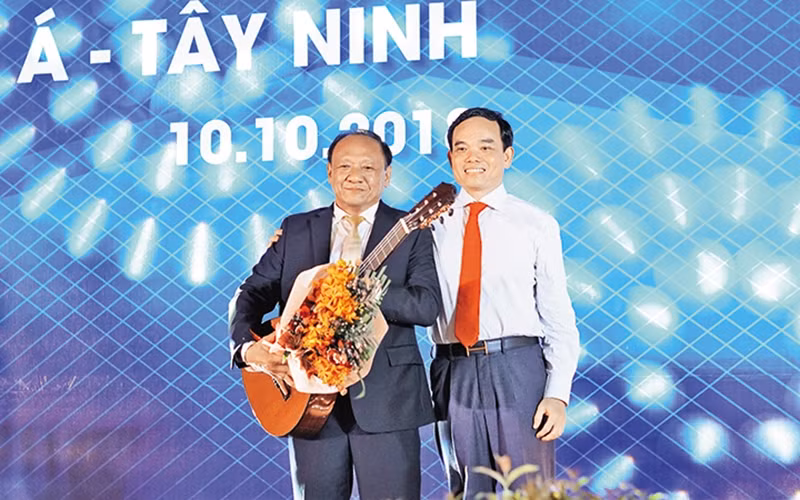 Bí thư Tỉnh ủy Trần Lưu Quang (bên phải) tặng đàn ghi-ta cho một nhà đầu tư.