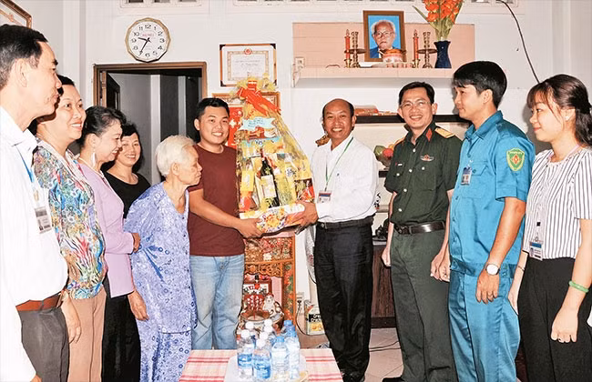 Đại diện chính quyền địa phương, cơ quan quân sự quận Tân Phú thăm hỏi, động viên gia đình thanh niên chuẩn bị nhập ngũ năm 2018.