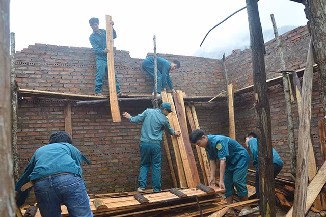 Dân quân xã Đồng Văn, huyện Bình Liêu (Quảng Ninh) giúp đỡ gia đình ông Chìu Quang Hiếng, ở bản Khe Tiền xây dựng nhà ở.