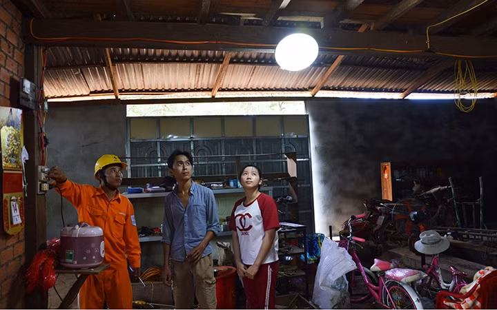 Công nhân Công ty Điện lực Đác Nông mắc điện lưới quốc gia cho các hộ nghèo.