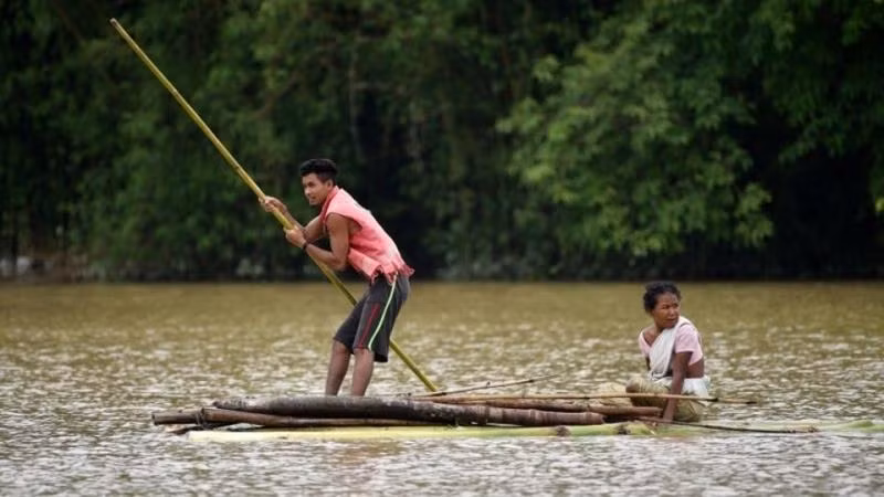 Người dân tự làm bè mảng để di chuyển trong điều kiện ngập lụt. (Ảnh: Reuters)