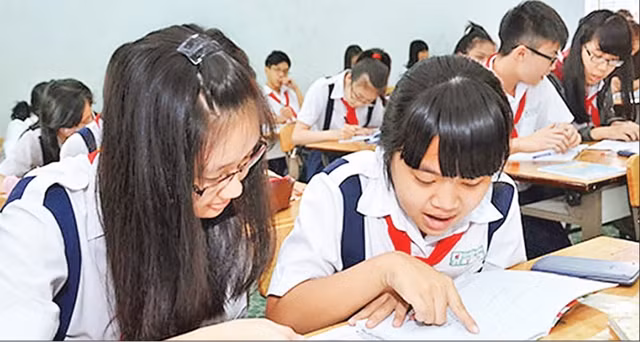 Học sinh lớp 9 Trường THCS Chu Văn An trao đổi bài trong giờ ôn tập môn Toán. Ảnh: TẤN THẠCH.