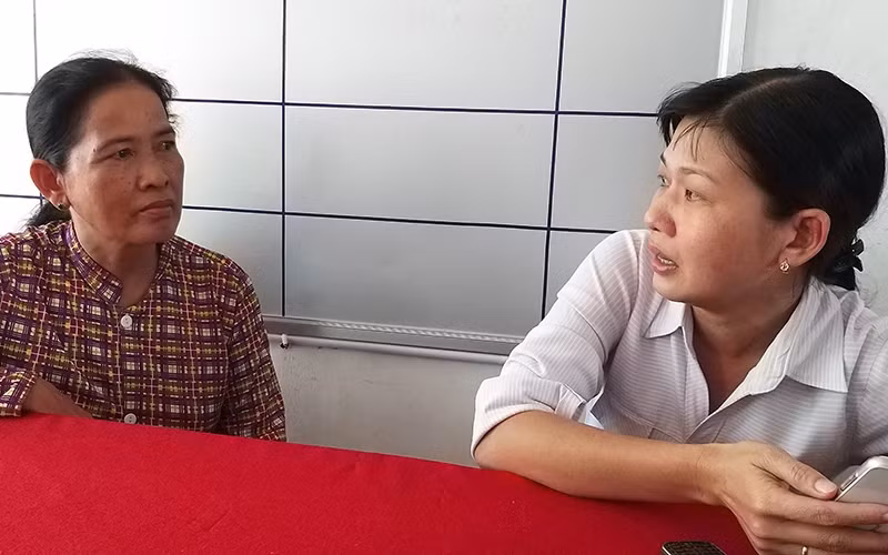 Cán bộ Hội Liên hiệp Phụ nữ xã An Hiệp, huyện Châu Thành, tỉnh Sóc Trăng (bên phải) tư vấn cho gia đình có người thân lấy chồng nước ngoài hồi hương.