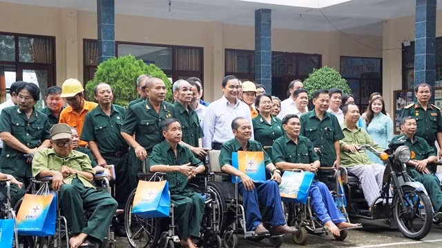 Ông Nguyễn Văn Hợp-Chủ tịch HĐTV EVNSPC (áo trắng, hàng trên) thăm và tặng quà các thương bệnh binh tại Trung tâm Điều dưỡng thương binh và người có công Long Đất, thị trấn Long Hải, huyện Long Điền, 