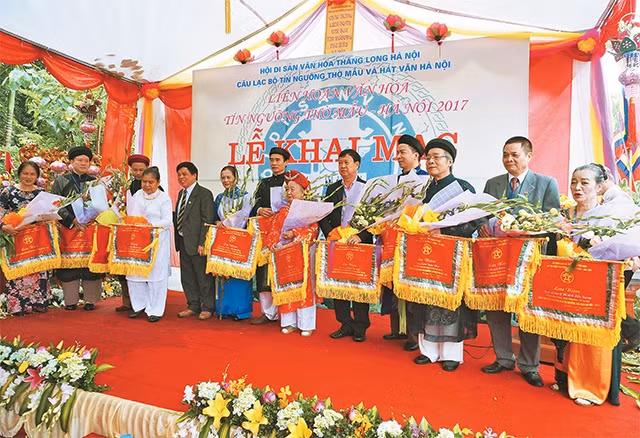 Đại diện Ban tổ chức trao Cờ lưu niệm cho các nghệ nhân tham gia Liên hoan Văn hóa tín ngưỡng thờ Mẫu.